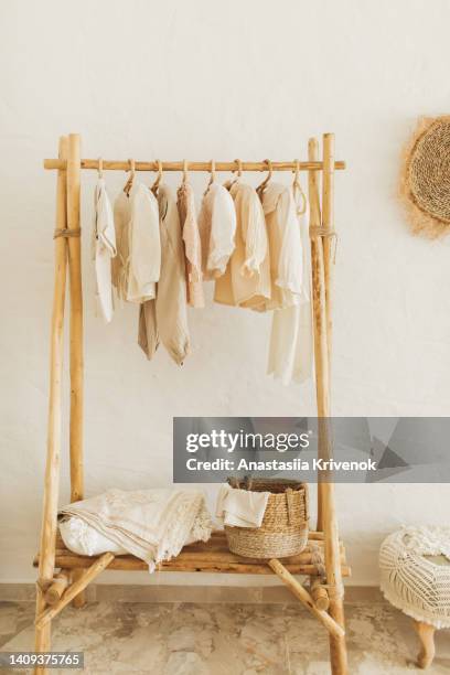 neatly hung clothes on hangers in wooden closet. - suit rack stock pictures, royalty-free photos & images