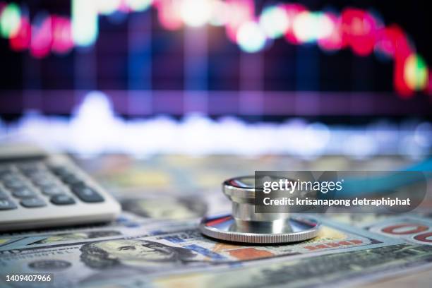 stethoscope and money,financial analysis, auditing or accounting - calculator calculators and dollar banknotes - bill legislation stock pictures, royalty-free photos & images