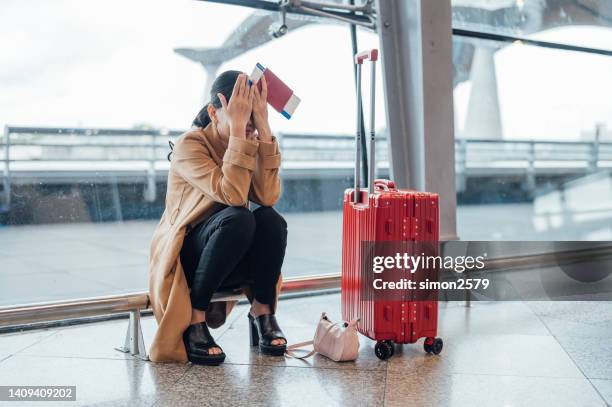 an asian woman upset and frustrated while flight canceled at the airport - airport frustration stock pictures, royalty-free photos & images