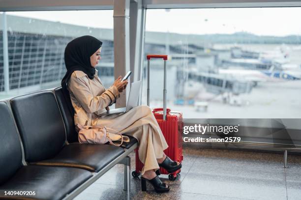 working and using phone while waiting on departure gate - véu imagens e fotografias de stock