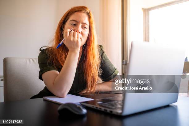 woman taking online courses with laptop and notebook and pen - pessoas notebook stock pictures, royalty-free photos & images