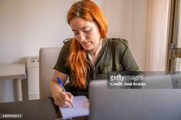 woman taking online courses with laptop and notebook and pen - pessoas notebook stock pictures, royalty-free photos & images