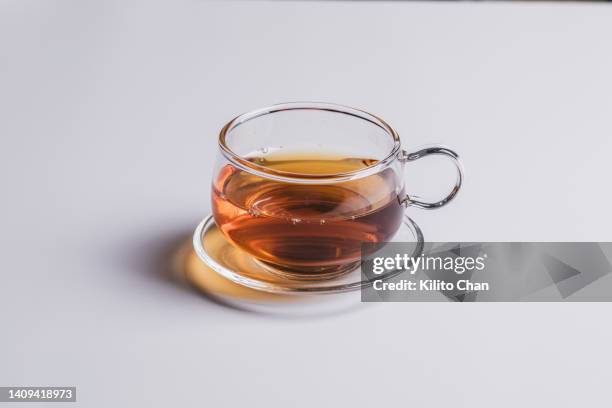 a cup of tea in a glass teacup - tè nero foto e immagini stock