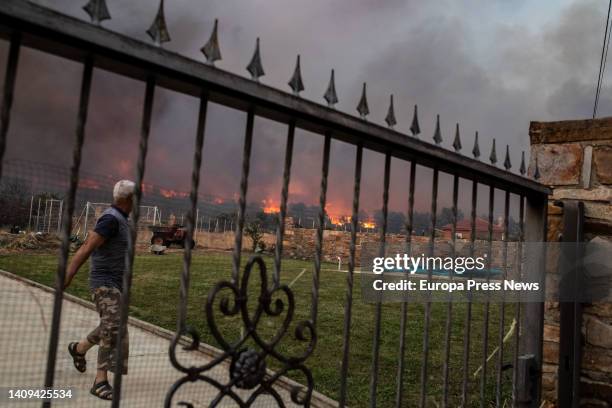 Neighbor watches the flames of the Losacio fire on July 17 in Losacio, Zamora, Castilla y Leon, Spain. A brigade member of a fire truck working to...