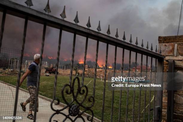 Neighbor watches the flames of the Losacio fire on July 17 in Losacio, Zamora, Castilla y Leon, Spain. A brigade member of a fire truck working to...