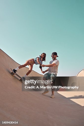 Father teaching his daughter how to skate in a ramp. Father teaching his daughter how to skate in a ramp.