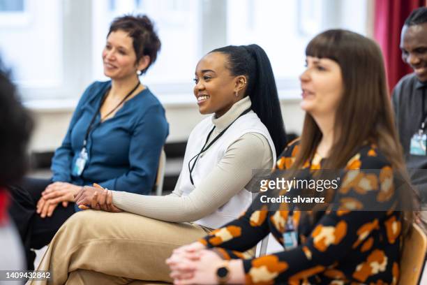 group of businesswomen sitting attentively in a seminar - attending course stock pictures, royalty-free photos & images