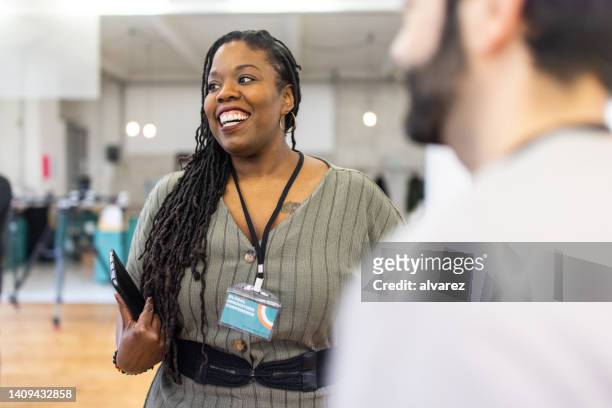 smiling african businesswoman networking at a conference - cliqueimages stock pictures, royalty-free photos & images