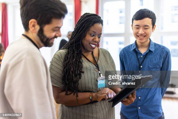 multiracial business team discussing using a tablet computer at conference event - cliqueimages stock pictures, royalty-free photos & images
