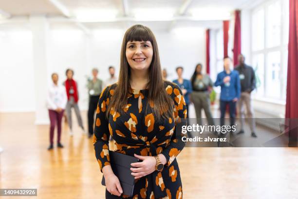 portrait of a smiling female entrepreneur at a conference - mid aged stock pictures, royalty-free photos & images