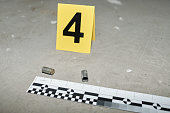 Yellow card with number four standing by two empty cartridge cases