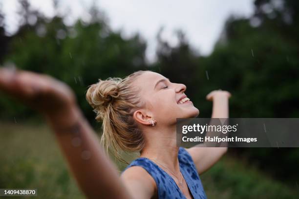portrait of beautiful blond woman standing in rain. - pendentif femme photos et images de collection