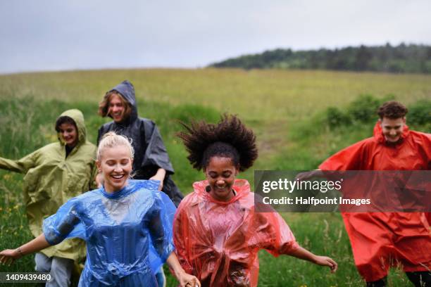 group of happy teenagers together outdoor, running in rain. - girl shower stock-fotos und bilder