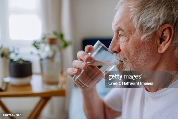 senior man drinking medicine. - wasser trinken stock-fotos und bilder