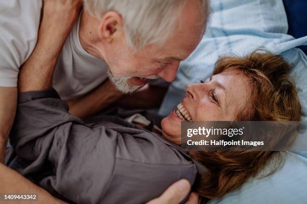 close-up of senior couple lying together in bed. concept of long lasting love. - par säng bildbanksfoton och bilder