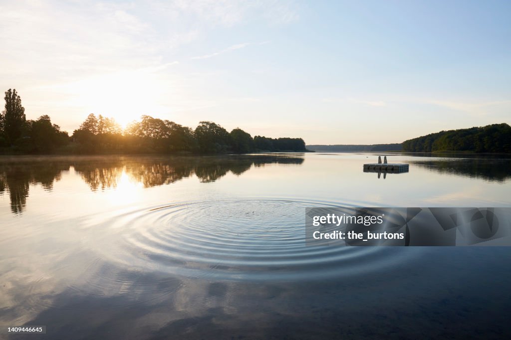 Lake and circular pattern on water surface at sunrise in summer