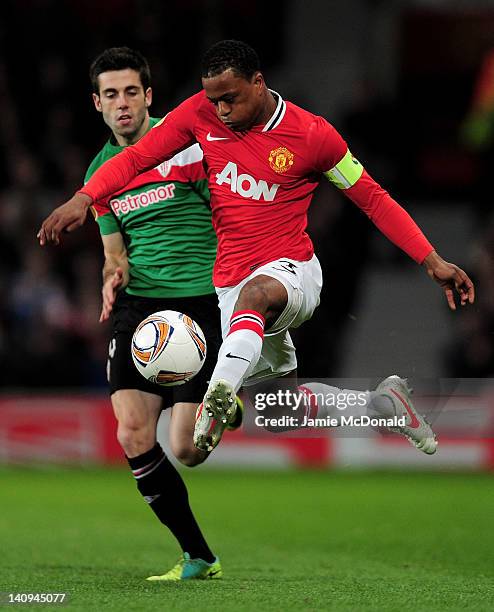 Markel Susaeta of Athletic Bilbao is beaten to the ball by Patrice Evra of Manchester United during the UEFA Europa League Round of 16 first leg...