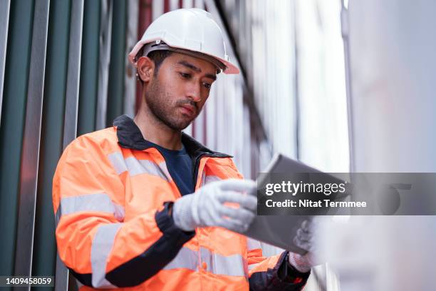 container loading and unloading inspections. male dock workers use a tablet computer to inspect a container based on a checklist to record the weather conditions, arrival time, and container number in a container yard. - inventory accuracy stock pictures, royalty-free photos & images