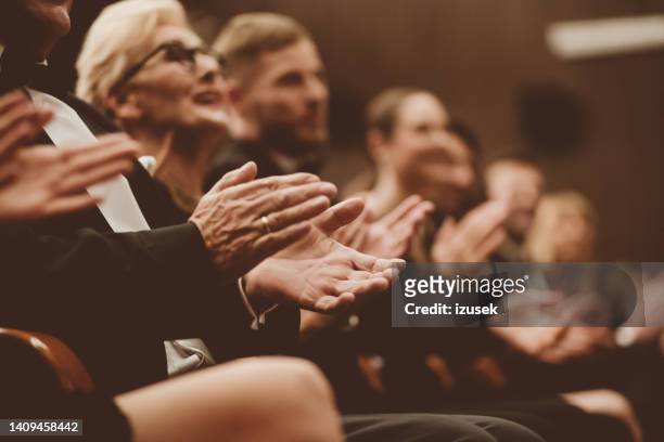 spectators clapping in the theater, focus on hands - arts for humanity gala imagens e fotografias de stock