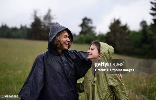 happy teenager couple together outdoor, running in rain, smiling. - rain couple stockfoto's en -beelden