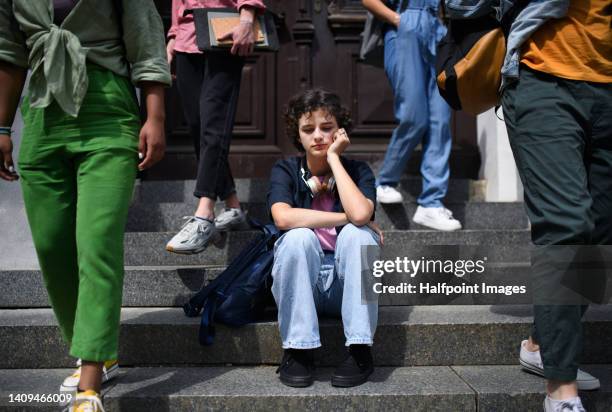 unhappy girl sitting alone in outdoor staircase. - invasion stock pictures, royalty-free photos & images