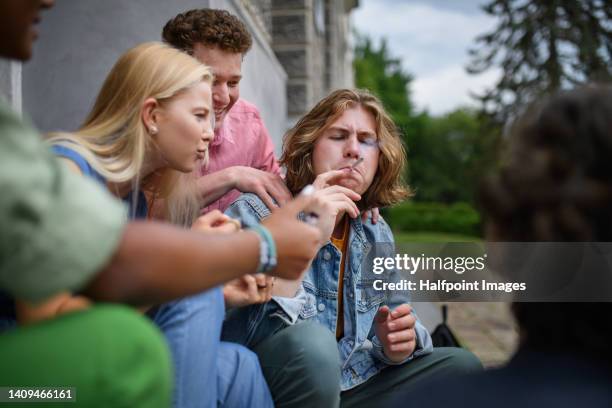 young teenager smoking marihuana cigarettes. - joint stockfoto's en -beelden