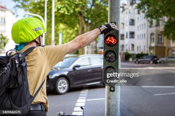 male cyclist waiting at red traffic light - car red light stock pictures, royalty-free photos & images