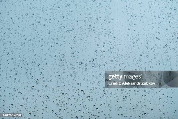 cloudy days, raindrops on the windows. rainy weather, rain background and bokeh. drops of water on the window glass against the blue sky after a shower. - windows surface stock pictures, royalty-free photos & images