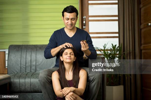 man giving oil head massage to wife at home - husband and wife massage 個照片及圖片檔