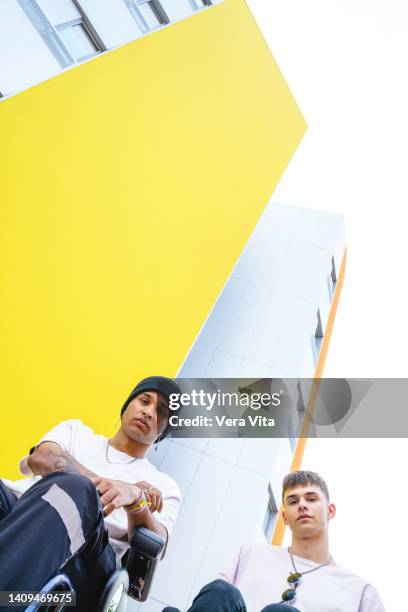 vertical view of latin american men sit on wheelchair outdoors. - man electric chair stock pictures, royalty-free photos & images