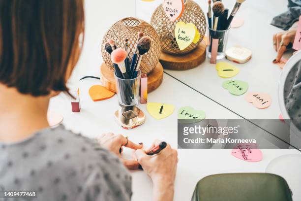 woman writing sticker with affirmations near the mirror. - health motivational quotes stock pictures, royalty-free photos & images