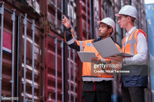 pre-entry condition survey and container inspections. male dock worker holding a digital tablet and explaining to his supervisors about an inspection of the storage and assessment of the storage conditions of the cargoes at a commercial dock. - storage solutions stock pictures, royalty-free photos & images