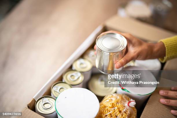 working at charitable foundation, packing donation box - charitable foundation stockfoto's en -beelden