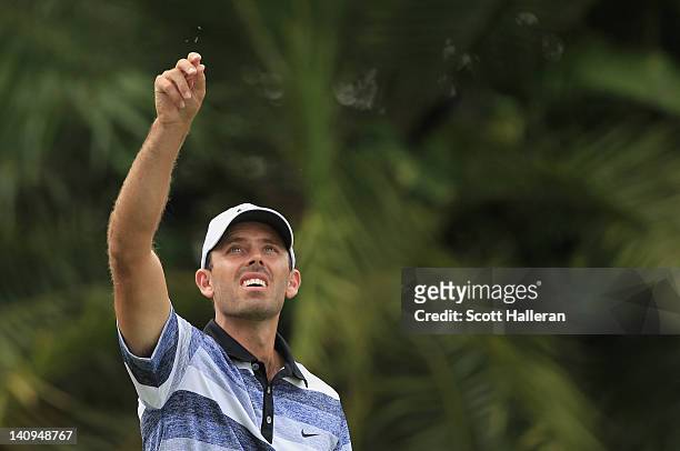 Charl Schwartzel of South Africa test the wind on the 15th hole during first round of the World Golf Championships-Cadillac Championship on the TPC...