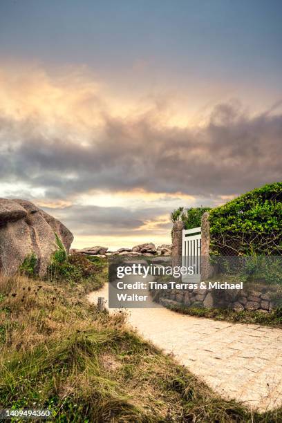 small white gate leading to the garden. in a rocky landscape in brittany in france. - formal garden gate stock pictures, royalty-free photos & images