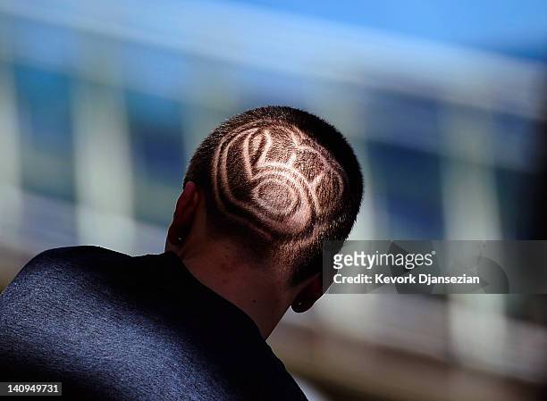 Fan with a haircut showing the Milwaukee Brewers logo follows the spring training baseball game against the Cincinnati Reds at Maryvale Baseball Park...