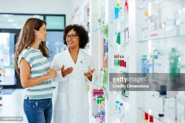 pharmacist talking with customer in drugstore - pharmacist stock pictures, royalty-free photos & images