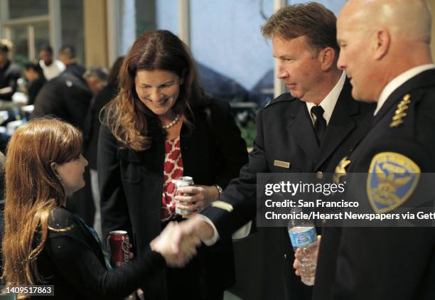 Suzy Loftus, center, looks at her daughter Maureen as she shakes hands with Captain Joe McFadden and with Police Chief Greg Suhr, far right, after a...