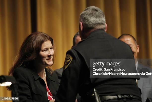 Suzy Loftus, left, shakes an officer's hand during a ceremony honoring SFPD medal of valor recipients at the Scottish Rites Masonic Center in San...