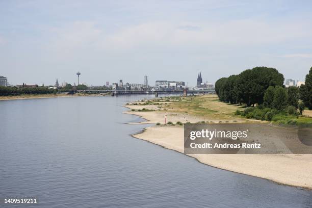 Banks and the low water in the River Rhine seen during a heat wave on July 18, 2022 in Cologne, Germany. The Rhine level is currently very low and...