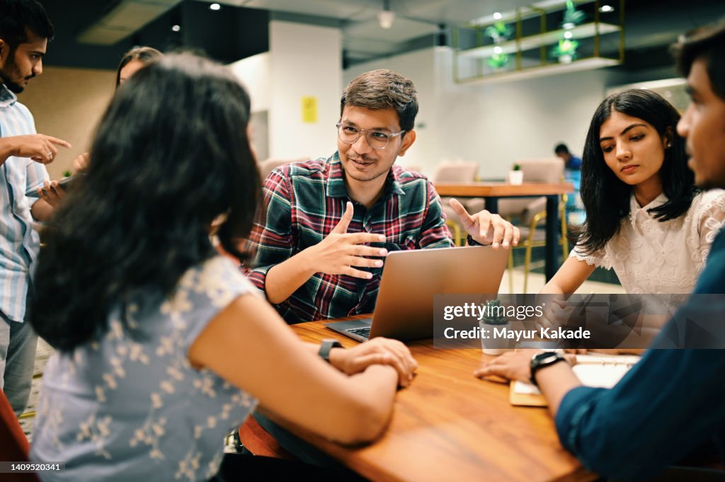 Gruppe junger Menschen diskutiert im Co-Working-Büro