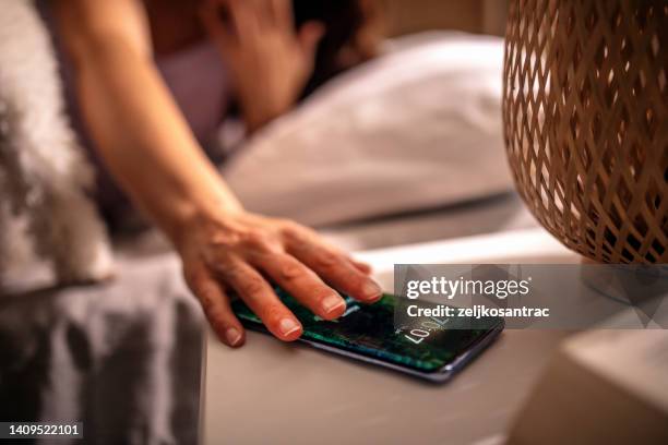 women sleeping with her maltese puppy on bed - alarm 個照片及圖片檔