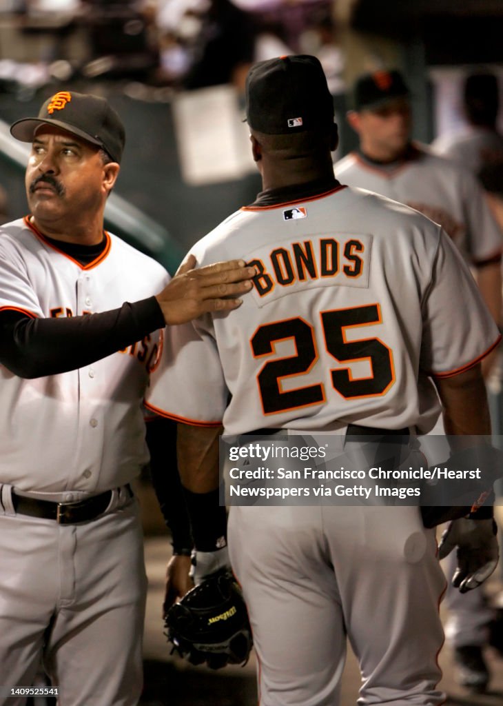 San Francisco Giants' first base coach, Luis Pujols pats Barry Bonds...  News Photo - Getty Images