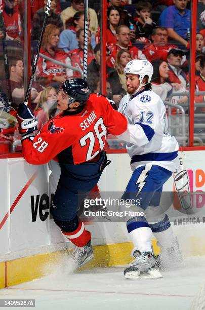 Alexander Semin of the Washington Capitals is checked into the boards by Ryan Malone of the Tampa Bay Lightning at the Verizon Center on March 8,...