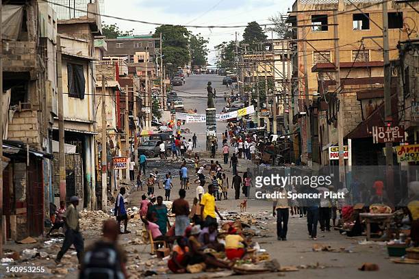 People walk through the streets of a market as tensions over the current Haitian presidents nationality spark unrest in the capital on March 7, 2012...