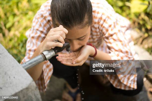 rural girl drinking tap water - drinking water shortage stock pictures, royalty-free photos & images