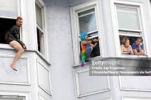Festivalgoers watch from the windows as the party continues at the Folsom Street Fair. Thousands attended the 25th anniversary Folsom Street Fair in...