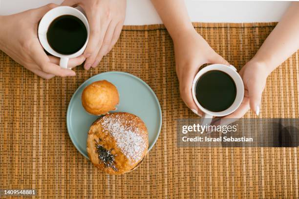 top view of unrecognizable couple having a delicious breakfast with buns and coffee. - muffin top stock-fotos und bilder