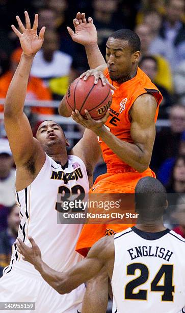 Oklahoma State Cowboys guard Markel Brown grabbed a rebound as Missouri Tigers center Steve Moore and Missouri Tigers guard Kim English defended in...