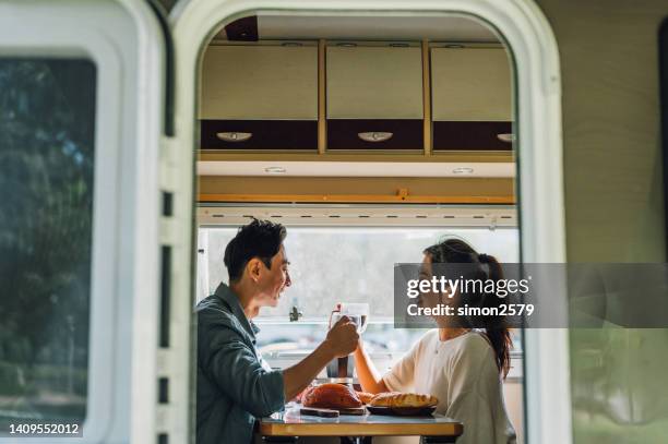lovely asian chinese couple enjoy breakfast with their camper van - camper van travel series - camper trailer stock pictures, royalty-free photos & images
